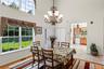Dining space featuring a towering ceiling, light wood finished floors, and a chandelier