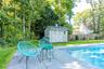 View of pool with a storage unit, a patio area, and view of wooded area