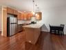 Kitchen with a peninsula, stainless steel appliances, pendant lighting, light stone countertops, and recessed lighting