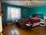 Bedroom with hardwood / wood-style flooring, baseboard heating, and ceiling fan
