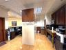 Kitchen featuring an office area, light wood finished floors, a drop ceiling, light countertops, and stainless steel microwave