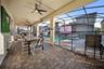 Private screen enclosed pool and hot tub with projector screen, outdoor dining, and lounge space.