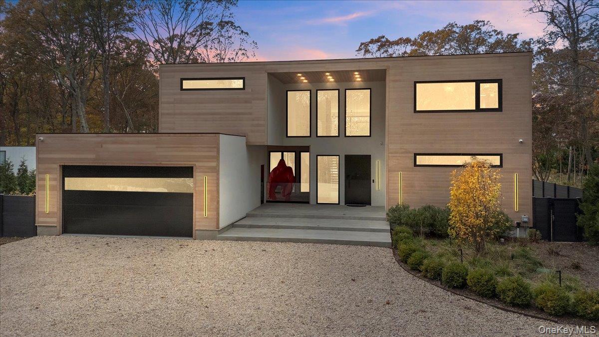 Contemporary home featuring gravel driveway and an attached garage