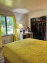 Bedroom with baseboard heating, a closet, and wood finished floors