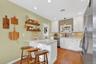 Kitchen with appliances with stainless steel finishes, white cabinetry, a breakfast bar, decorative light fixtures, and recessed lighting