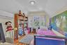 Hardwood flooring with a natural finish, multiple windows providing natural light, a built-in bookshelf, and a ceiling-mounted light fixture