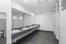 Bathroom featuring a paneled ceiling, baseboards, and double vanity