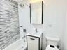 Full bathroom with vanity, shower / bath combination, and tile walls