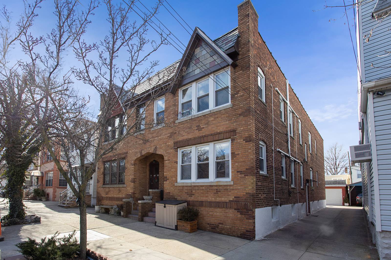 Exquisite semi detached 2 family brick Tudor with oversized two car garage in Upper Glendale.