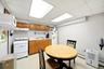 Kitchenette featuring wood cabinetry, a gas range, a sink with a countertop