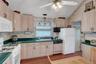 Eat-in kitchen with wood cabinets, Corian countertops, and Cath Ceiling