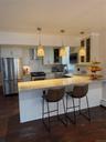 Kitchen with refrigerator, dark wood-style floors, a peninsula, range, and extractor fan