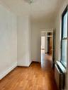Spare room featuring light wood-type flooring, radiator, and an ornate ceiling