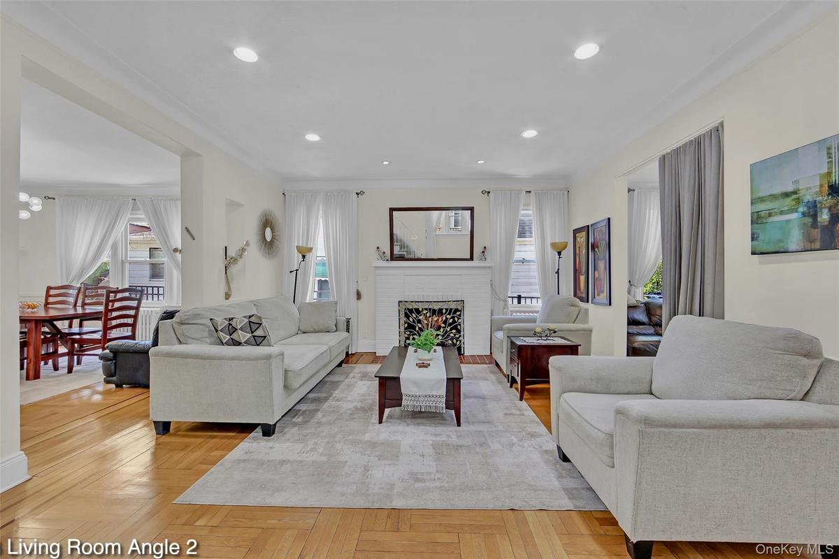 Spacious living area featuring light wood-finish flooring, recessed lighting, and crown molding