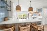 Kitchen with light stone countertops, a breakfast bar, open shelves, recessed lighting, and crown molding
