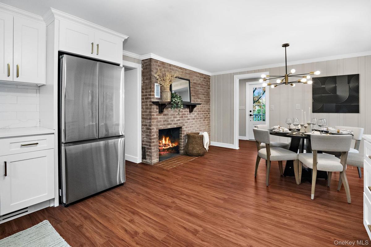 The heart of the home — this open kitchen and dining area blend modern design with a touch of classic warmth, anchored by a second brick fireplace.
