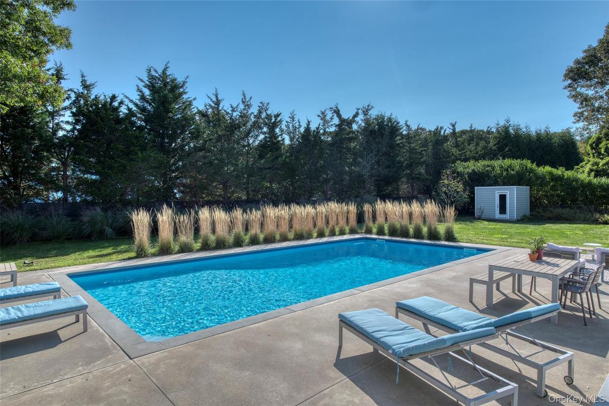 View of pool featuring a patio, an outdoor structure, and a lawn