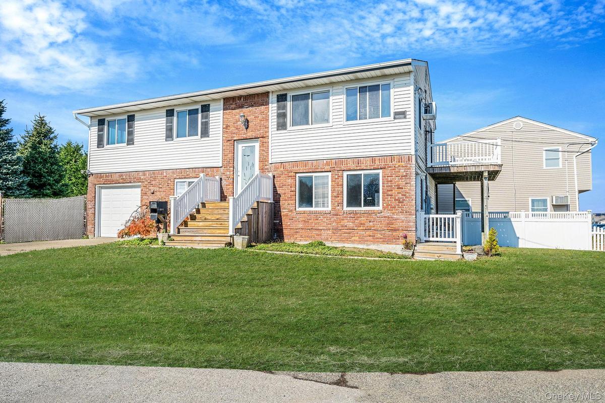 Bi-level home featuring brick siding, driveway, and an attached garage