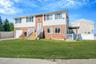 Bi-level home featuring brick siding, driveway, and an attached garage