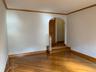Unfurnished room with ornamental molding, light wood-style flooring, and arched walkways