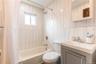 Bathroom featuring shower / tub combo with curtain, vanity, and tile walls