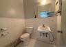 Bathroom featuring baseboard heating, sink, tile walls, tile patterned flooring, and toilet