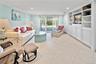 Living room with recessed lighting, built in shelves, light tile patterned floors, and crown molding