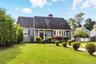 View of front of house with a front lawn, a chimney, roof with shingles, and entry steps