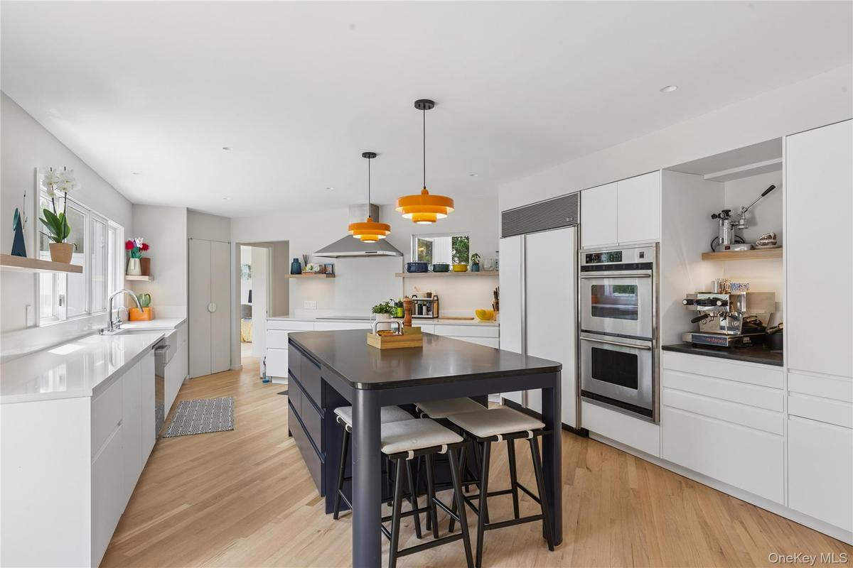 Newly renovated Contemporary kitchen featuring light wood-finish flooring, convection burners, and a central island