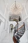 Stairway featuring a decorative wall, a chandelier, arched walkways, recessed lighting, and marble finish floors