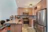 Kitchen with a kitchen breakfast bar, appliances with stainless steel finishes, a peninsula, light stone countertops, and recessed lighting