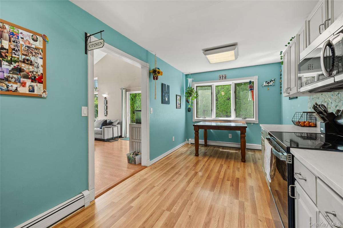 Kitchen with light wood-finish flooring, white cabinetry, and light countertops