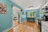Kitchen with light wood-finish flooring, white cabinetry, and light countertops