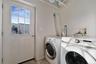 Dedicated laundry area featuring hookups for washer and dryer, a utility door with grid-patterned glass, and a concrete floor