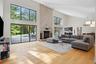 Living room with a towering ceiling, light wood-style floors, and a large fireplace