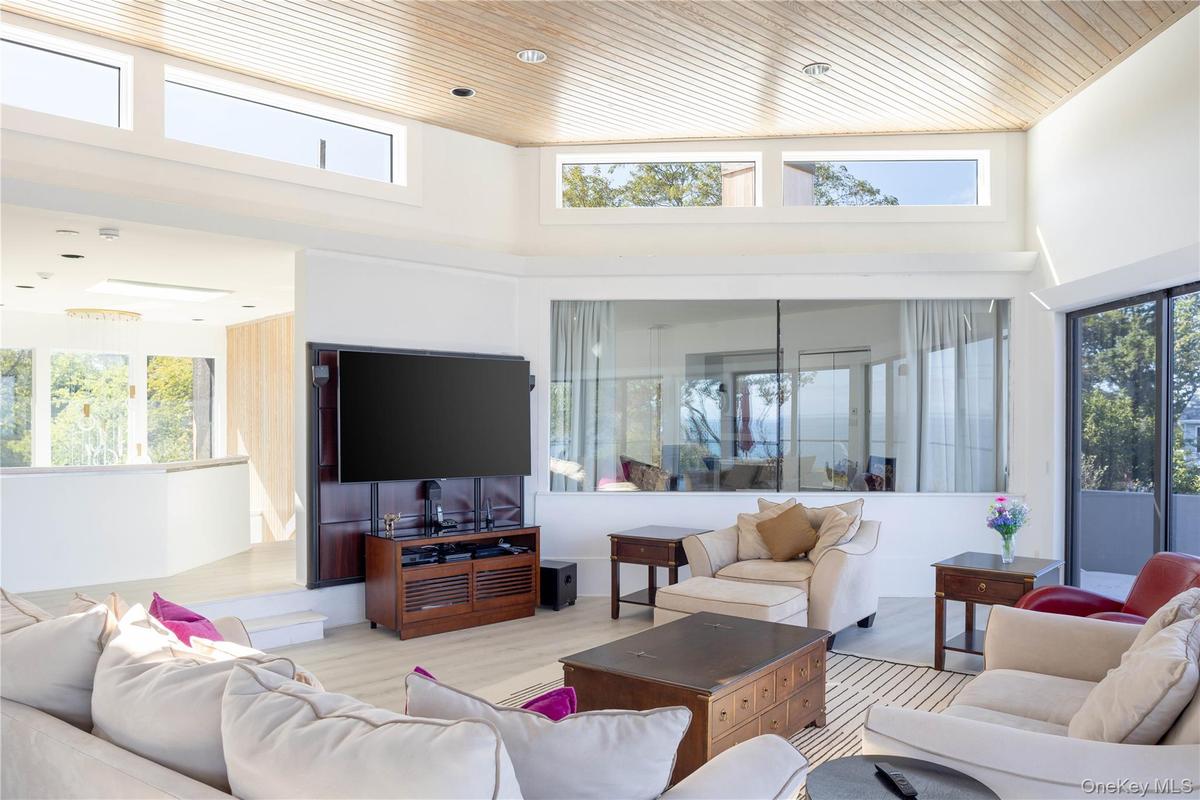 Living area featuring wood ceiling, a high ceiling, and a wealth of natural light