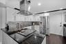 Granite counter tops and enclosed vent hood keep the sleek design in the kitchen.