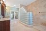 Primary Bathroom with dual granite vanities, Spacious Walk-In Shower with 7 heads and detachable hose and a large, separate tub