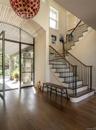 Stairway with wood-type flooring, a high ceiling, and a wall of windows