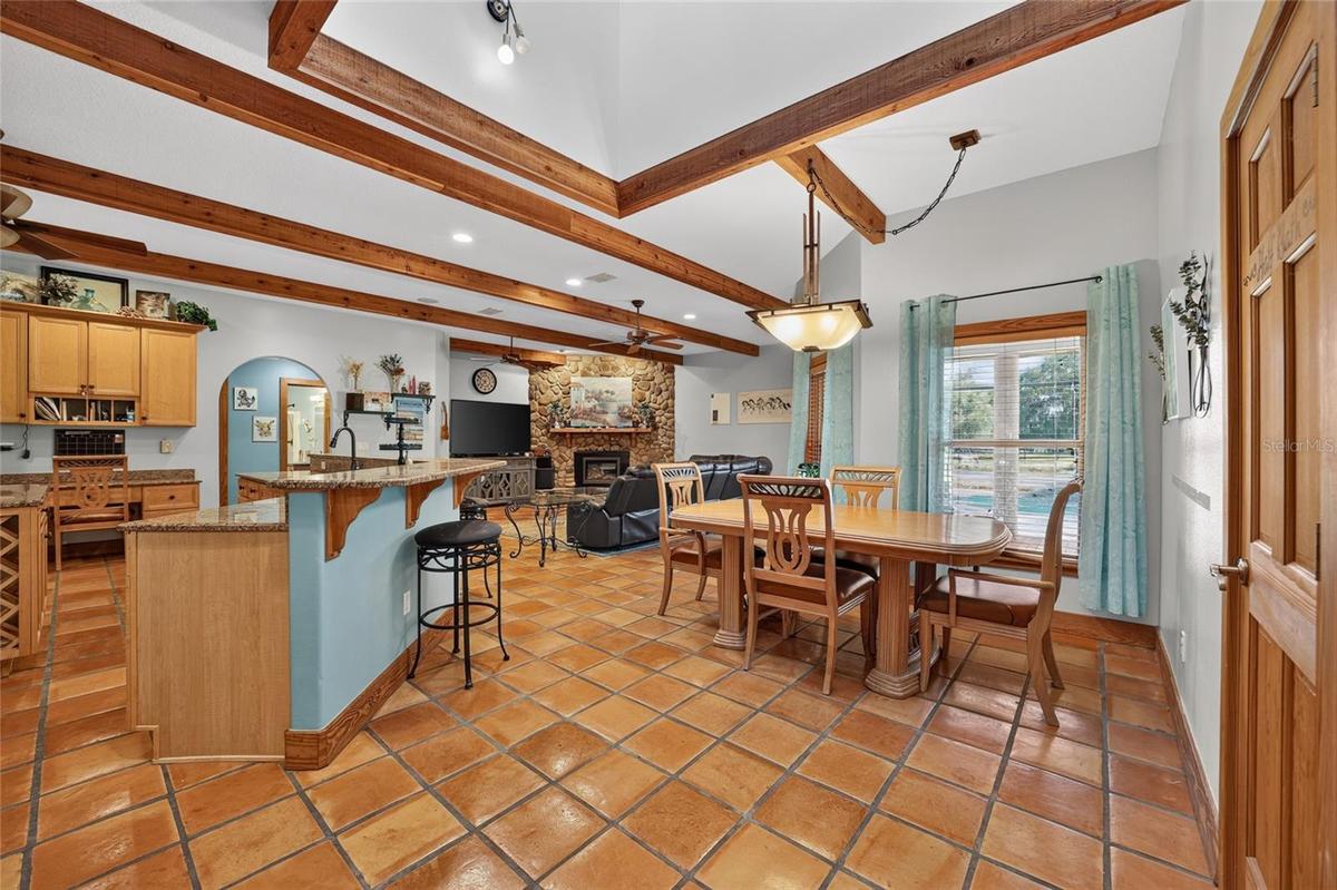 Open-Concept Gourmet Kitchen, Dining & Family Room with Exposed Wood Beams