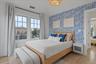 Bedroom featuring wood finished floors and wallpapered walls