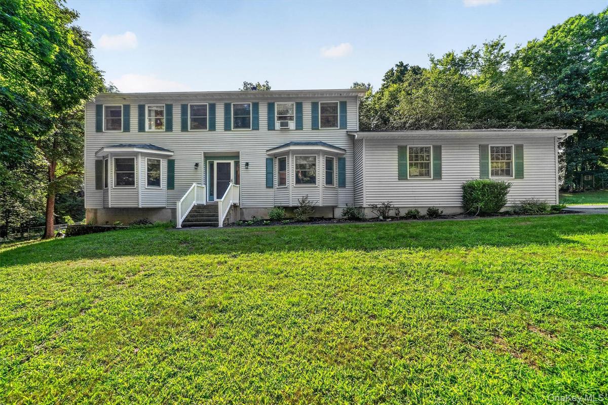 Two-story residence featuring light-toned siding and green shutters