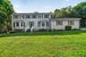 Two-story residence featuring light-toned siding and green shutters