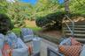 Tucked beneath a canopy of mature trees, this secluded patio off of the playroom creates a peaceful extension of the lower level and a quiet place to