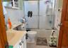 Full bathroom with vanity, tile patterned flooring, toilet, enclosed tub / shower combo, and tile walls
