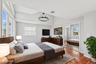 Second Floor Primary Bedroom with full en-suite and large closets with custom cabinets. Vaulted ceilings accent this room with wood-finish flooring