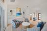 The living room has all new furnishings, a frameless TV and plenty of light from the sliders that go directly into the pool area.
