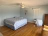 Bedroom featuring baseboards, a ceiling fan, visible vents, and wood finished floors