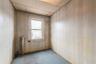Unfurnished room with light carpet, wood walls, radiator heating unit, and a drop ceiling