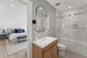 Bathroom with shower / bath combination with glass door, vanity, connected bathroom, recessed lighting, and tile walls